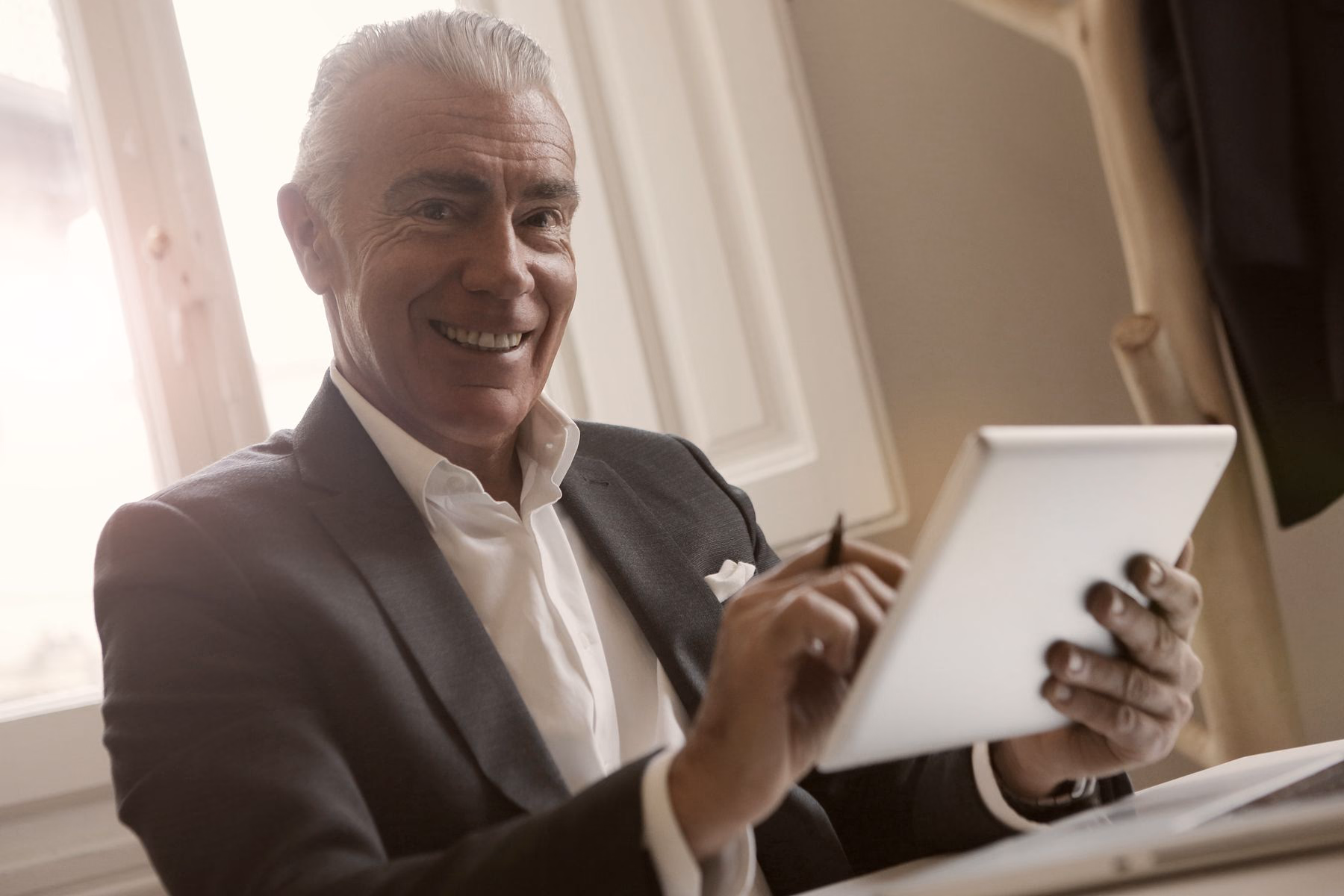 A mortgage broker using a tablet in his office